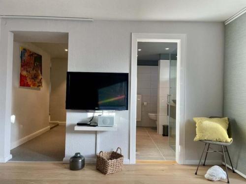 a living room with a flat screen tv on a wall at Holiday apartment in Plön with swimming pool in Plön