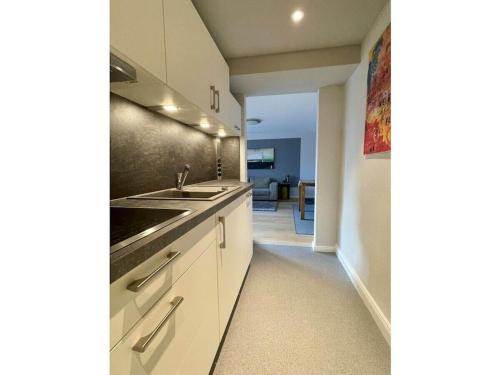 a kitchen with white cabinets and a sink at Holiday apartment in Plön with swimming pool in Plön