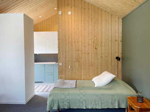 a bedroom with a bed and a wooden wall at 4 person holiday home in Vaxholm in Vaxholm