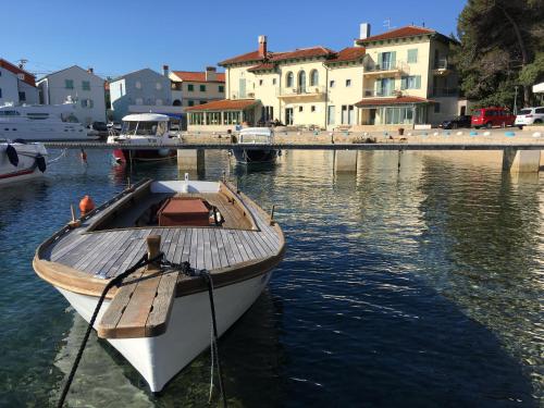 a boat tied to a dock in the water at Hotel Televrin in Nerezine