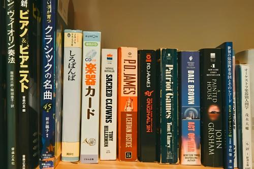a row of books on a book shelf at Guest House Chaconne Karuizawa in Karuizawa