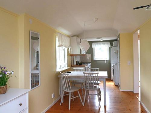 a kitchen with a table and chairs in it at 4 star holiday home in MELLBYSTRAND in Mellbystrand