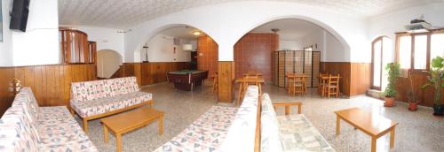 - un salon avec des chaises, une table et un billard dans l'établissement Hostal Montaña, à Sant Antoni de Portmany