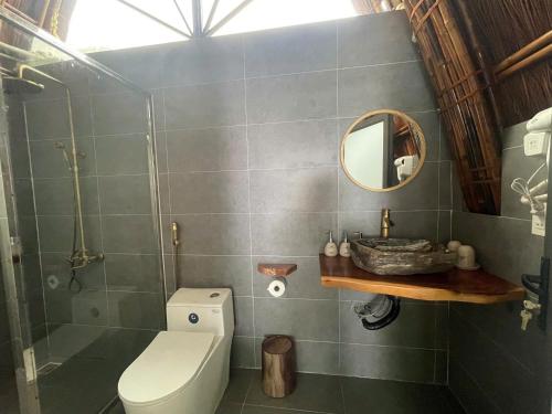 a bathroom with a toilet and a mirror at Cat Ba Holiday Retreat in Cat Ba