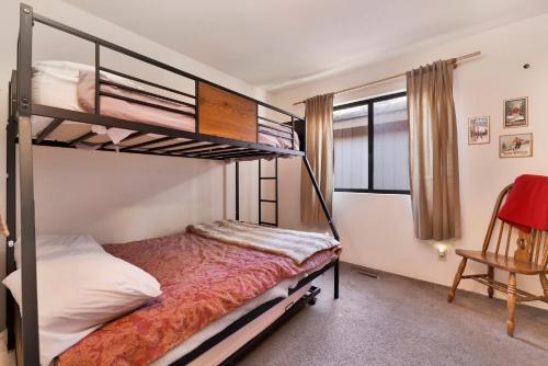 a bedroom with two bunk beds and a chair at Brown bears cabin #1091 in Big Bear Lake