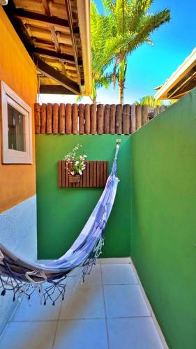 a hammock in a room with a green wall at Villa Baobá Pousada & Spa in Búzios