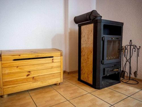 a wood stove sitting next to a wooden dresser at at the lake with a boat in Spychowo