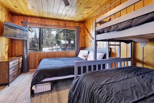 zwei Etagenbetten in einem Zimmer mit Fenster in der Unterkunft Shore acres lodge #450 in Big Bear Lake