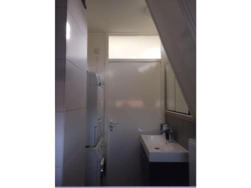 ein weißes Badezimmer mit Waschbecken und Spiegel in der Unterkunft Holiday apartment in Alkmaar in Alkmaar