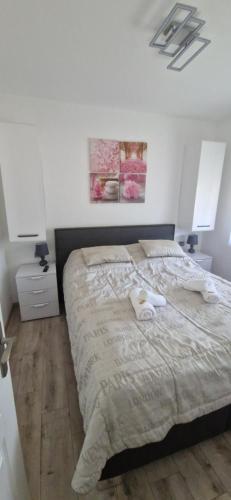 een slaapkamer met een bed met twee handdoeken erop bij Rozmaring Apartman Csopak in Csopak