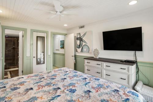 a bedroom with a bed and a flat screen tv at 133 Captain John Fripp - 3 BD/2 BA with Resort Amenities! in Fripp Island