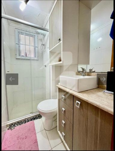 a bathroom with a toilet and a sink and a shower at Apartamento próximo ao centro e Havan in Gravataí