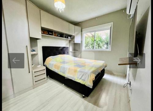 a small bedroom with a bed and a window at Apartamento próximo ao centro e Havan in Gravataí