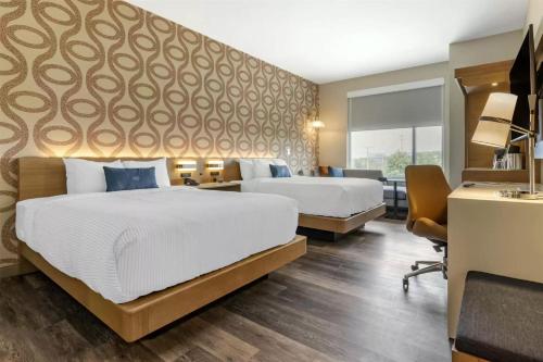 a hotel room with two beds and a desk at DoubleTree by Hilton Greenville Woodruff Road in Greenville
