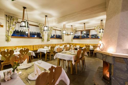 a restaurant with tables and chairs and a fireplace at Hotel Willa Pod Skocznią in Zakopane