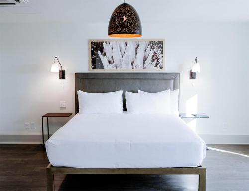 a bedroom with a white bed and a pendant light at Sea Palms Resort St Simons Island in Saint Simons Island