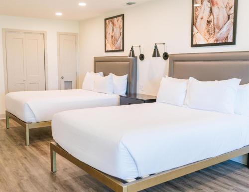 two beds in a hotel room with white sheets at Sea Palms Resort St Simons Island in Saint Simons Island