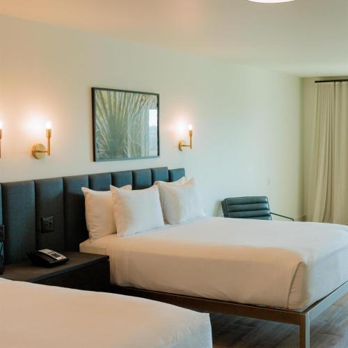 a hotel room with two beds and a chair at Sea Palms Resort St Simons Island in Saint Simons Island