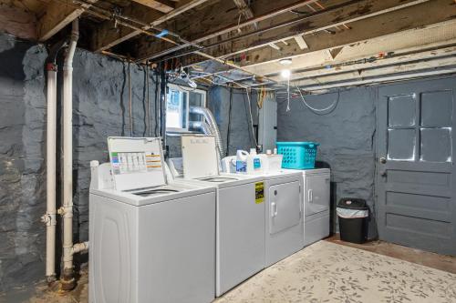 a laundry room with washing machines and a blue door at Forest Park Oasis | JZ Vacation Rentals in Tower Grove