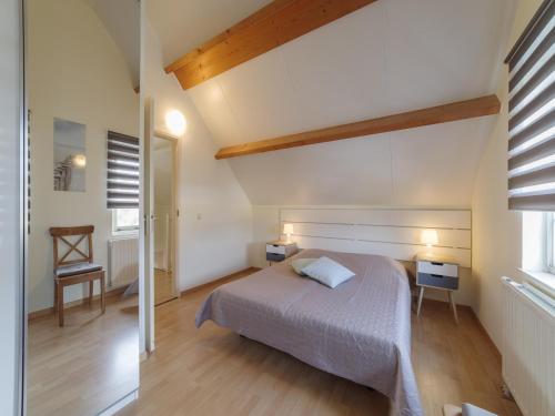 a bedroom with a bed and a table and a chair at Holiday Home in Quiet Park with Garden in Wemeldinge