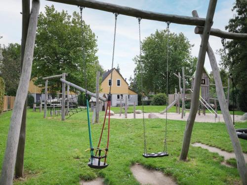 an empty playground with swings in a park at Holiday Home in Quiet Park with Garden in Wemeldinge