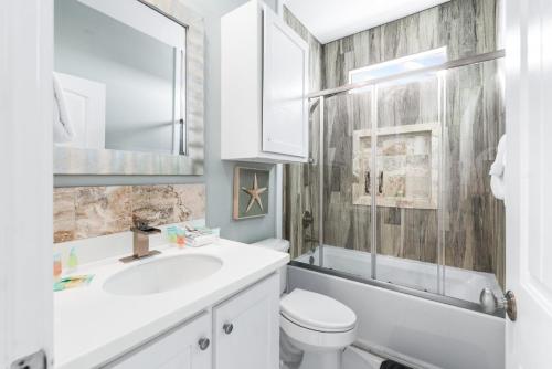 un bagno bianco con lavandino e WC di Sandy Coral - Golf Cart Included! a Mustang Beach