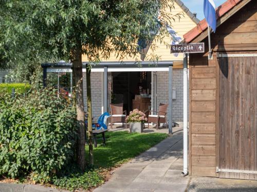 a garage with a street sign in front of a house at Holiday Home in Quiet Park with Garden in Wemeldinge