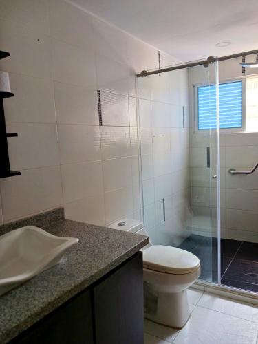 a bathroom with a toilet and a glass shower at Atardeceres del Laguito in Cartagena de Indias