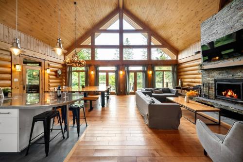 ein Wohnzimmer mit Kamin in einem Blockhaus in der Unterkunft Chalet Mazama - Private Lake - Hot Tub - 16P in Wentworth-Nord
