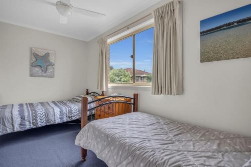 a bedroom with two beds and a window at Lakeside Apartments 8 in Merimbula