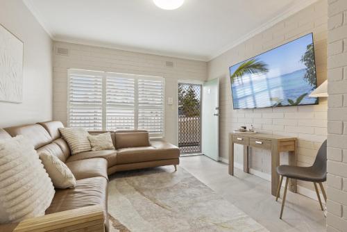 a living room with a couch and a table at Bright 2-Bed Apartment Steps from Largs Bay Beach in Largs