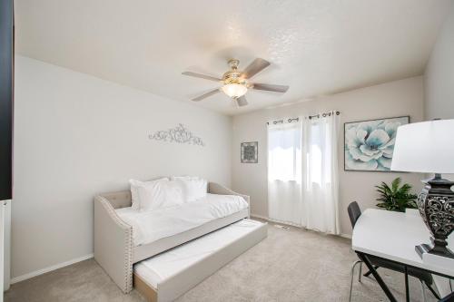 sala de estar con sofá blanco y ventilador de techo en True Blue Family Home, en Meridian
