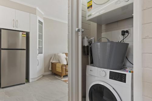 a laundry room with a washer and dryer at Bright 2-Bed Apartment Steps from Largs Bay Beach in Largs