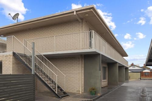 a building with a staircase on the side of it at Bright 2-Bed Apartment Steps from Largs Bay Beach in Largs