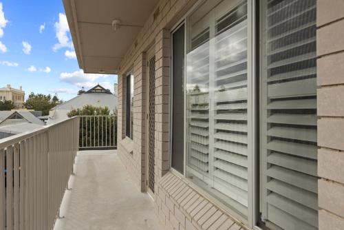 a balcony with blinds on a house at Bright 2-Bed Apartment Steps from Largs Bay Beach in Largs
