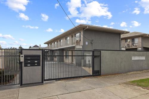a house with a gate in front of a fence at Bright 2-Bed Apartment Steps from Largs Bay Beach in Largs