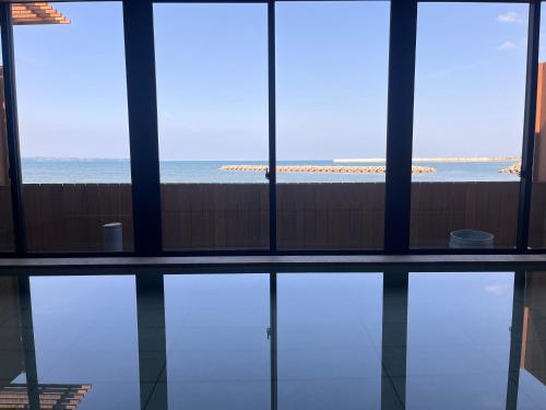 a room with a view of the ocean from a building at Ishinoya Beppu - TKP Hotels & Resorts in Beppu