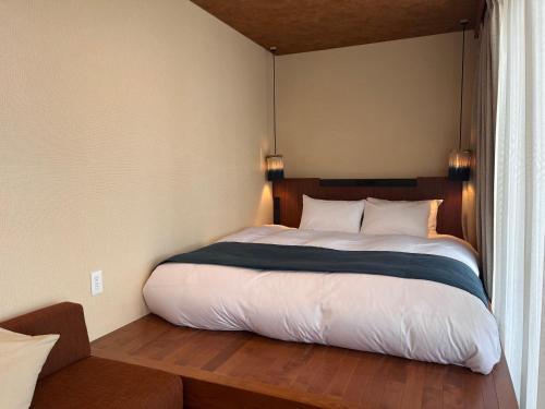 a bedroom with a large bed with a window at Ishinoya Beppu - TKP Hotels & Resorts in Beppu