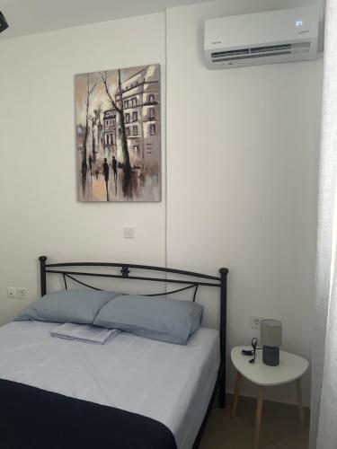 a bedroom with a bed and a picture on the wall at Οι δίδυμες σουίτες in Nafpaktos