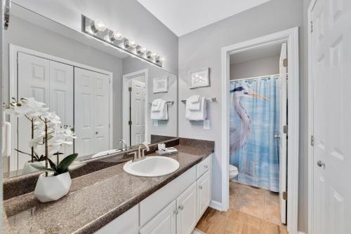 a bathroom with a sink and a bird in the mirror at Cozy 2BD/2BA w/ View, Sleeps 6 in Orange Beach