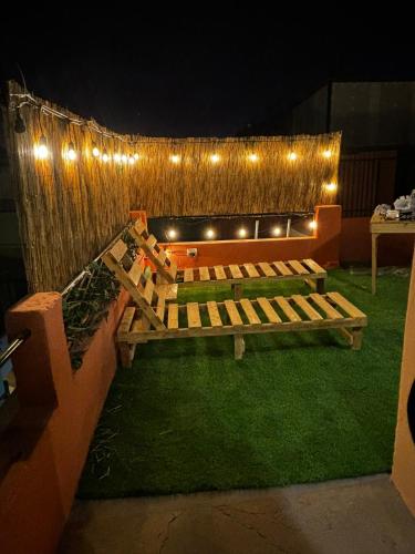 a patio with a bench and lights on a fence at Olespier Hostel in Arequipa