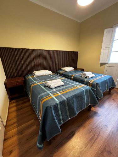 two beds in a room with blue blankets at Olespier Hostel in Arequipa