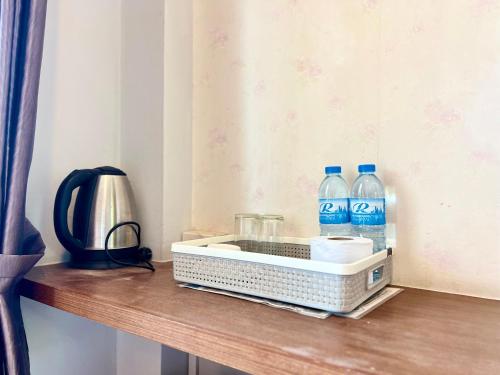 a bottle of water and two bottles of water on a table at Rungreang Hotel in Ban Phai