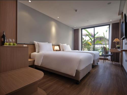 a large bedroom with two beds and a large window at Minasi Grand Hotel in Hanoi