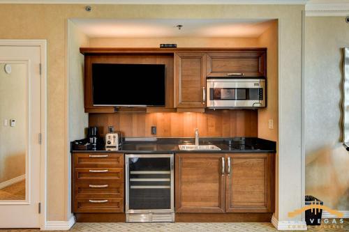 a kitchen with wooden cabinets and a sink and a microwave at MGM Signature-03-611 Strip View Jacuzzi Studio in Las Vegas
