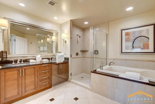 a bathroom with a tub and a shower and a sink at MGM Signature-03-611 Strip View Jacuzzi Studio in Las Vegas