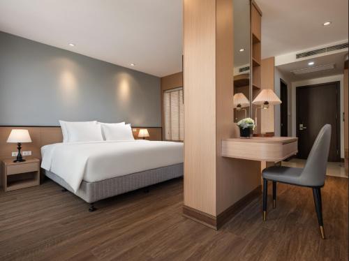 a bedroom with a bed and a desk and a chair at Minasi Grand Hotel in Hanoi