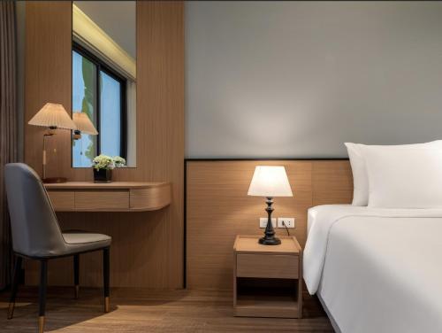 a bedroom with a bed and a desk and a chair at Minasi Grand Hotel in Hanoi