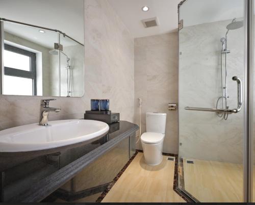 a bathroom with a sink and a toilet and a mirror at Minasi Grand Hotel in Hanoi