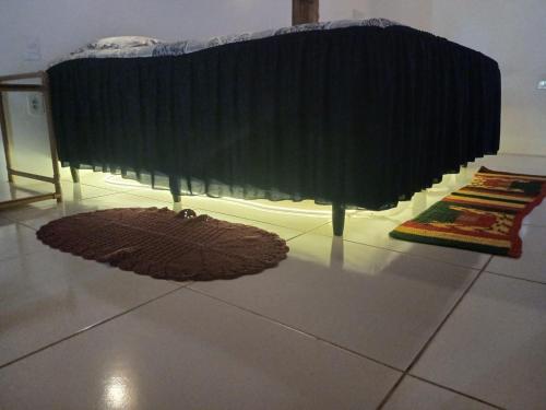 a bedroom with a bed and a rug on the floor at Atins Casa limão in Barreirinhas